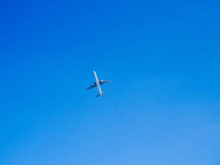 silhouette of airplane flying over the blue skies, aloneの写真素材