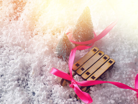 Christmas concept, toy santa sleigh, gift boxes on snow and blur bokeh, Empty wooden sled.