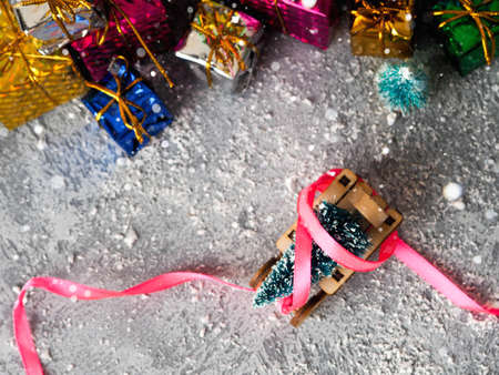 Christmas concept, toy santa sleigh, gift boxes on snow and blur bokeh, Empty wooden sled.の写真素材