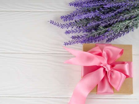 Small gift box decorated with ribbon and flower, Beautiful romantic gift box on wood.の写真素材