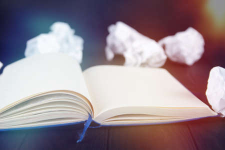 White note pad on a wooden table. Writing concept - crumpled up paper wads with Notepadの写真素材