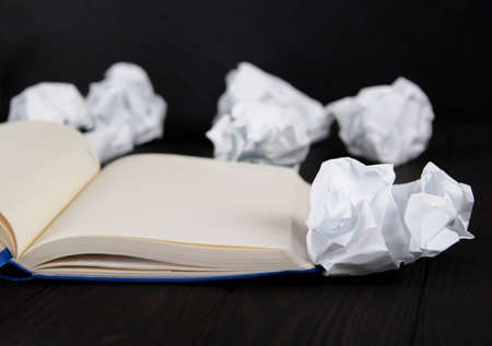 White note pad on a wooden table. Writing concept - crumpled up paper wads with Notepadの写真素材