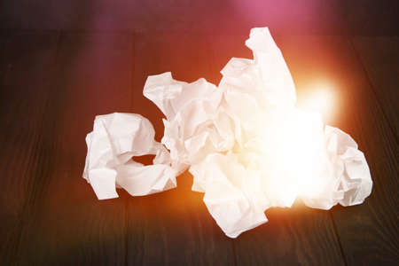 White note pad on a wooden table. Writing concept - crumpled up paper wads with Notepadの写真素材