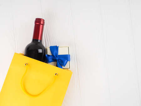 bottle of wine and flowers in the package on wooden background, space for text.の写真素材