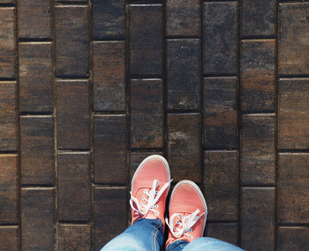 a pair of pink sneakers on the wet asphalt