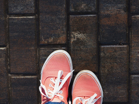 a pair of pink sneakers on the wet asphalt.