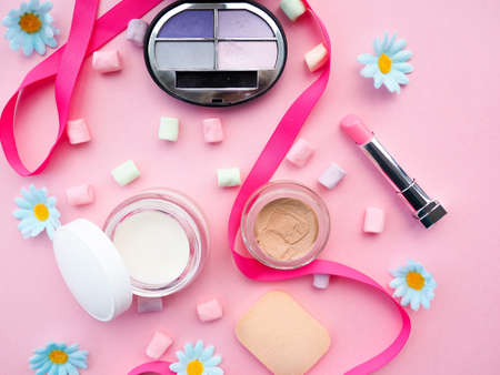 Many cosmetics on pink background, brush, lipstick ribbonの写真素材