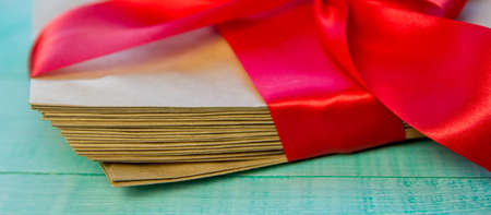 Old letters tied with a red ribbon on old wooden background, top view, paper craftの写真素材