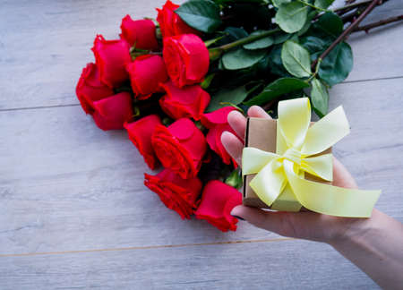 female hands tying bow on gift box, space for text.の写真素材