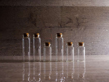 many small glass bottles used in medicine on paper background.の写真素材