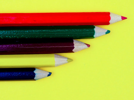colored pencils on a yellow background, space for text.