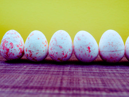 colored eggs for Easter on a bright yellow background, copy space for text, sun