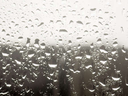 Water drop on the glass of windows background, raining on the glass off window city for backgroundの写真素材