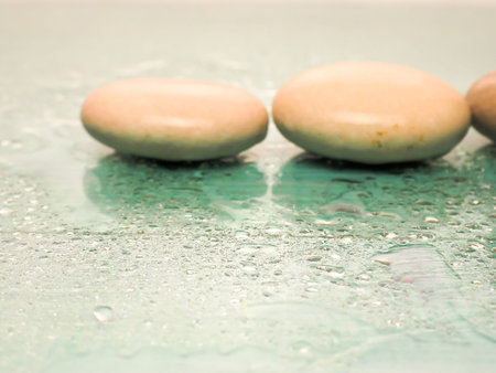 Massage stones, pebbles on a green background.