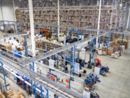 Warehouse interior, Warehouse industrial and logistics companies. Commercial warehouse. Boxes and crates stocked on the shelves of three storey. The effect of motion blur. Bright sunlightの写真素材