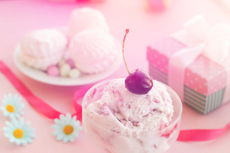 ice cream in a Cup next to the marshmallows, flowers, pink sweets.