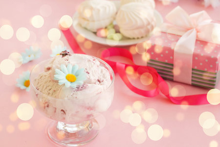 ice cream in a Cup next to the marshmallows, flowers, pink sweets.