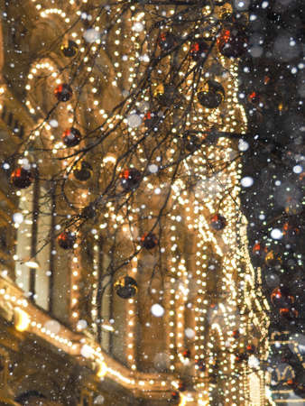 Festive illuminations in the streets of the city, tree with bright red and yellow ballsの写真素材