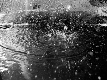 squirt a drop of water, colorless water spray close, dark tone.の写真素材