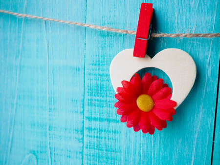 Gingham Love Valentine's hearts natural cord and red clips hanging on rustic driftwood texture background, copy space.の写真素材