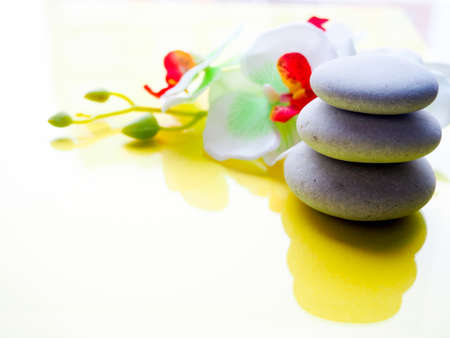 Spa pink orchid with massage stones on blue wooden backgroundの写真素材