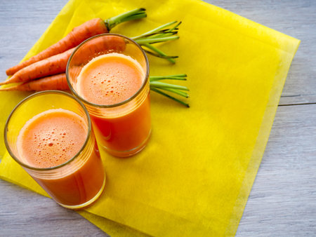 Glasses of carrot juice with vegetables on table close upの写真素材