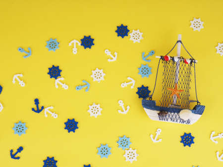 Vintage sailing boat ship on yellow. Wooden marine miniature, handmade souvenirs, realistic models, the concept of home away from homeの写真素材