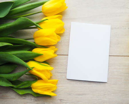 Yellow tulips on wooden background copy space.の写真素材
