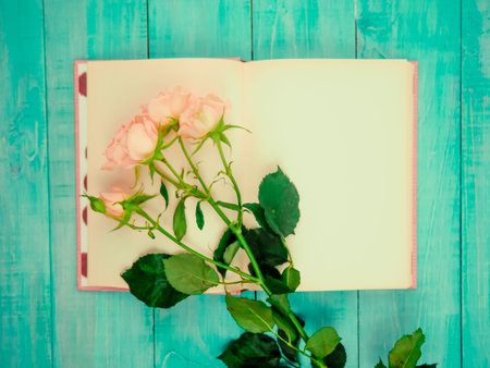 Love or valentine's day concept. Red beautiful roses in envelope on a wooden background. Top view.