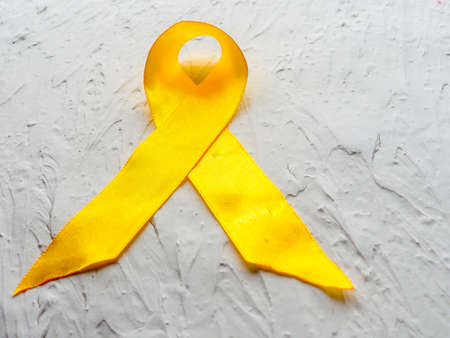 Yellow awareness ribbon on white textured background.の写真素材