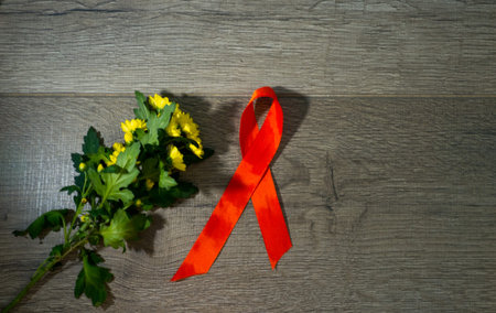 Red ribbon awareness on old aged wood background: World aids day symbolic concept concerns help and...