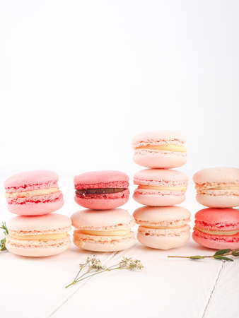 Colorful French or Italian macarons stack on white wood table with copy space for background. Dessert for served with afternoon tea or coffee breakの写真素材