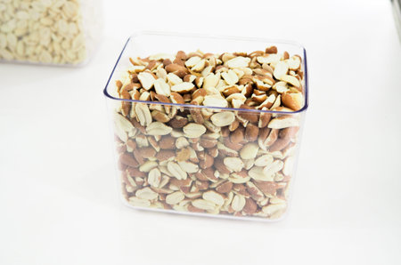 Nut mix in glass jars, hazelnuts, almonds, cashew on white background. Selective focus, copy space