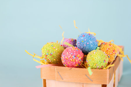 Easter eggs in egg cartoon box on blue background close up. Festive decorations. Happy Easter