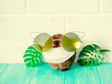 the concept of a global pandemic coronavirus, coconut in a homemade mask to sit at home in the...