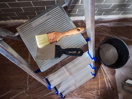 Finishing work in a newly built house, Step ladder and decorator s tools near wall repair tools.の写真素材