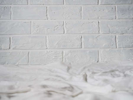 background, backing white brick wall and white bed, fabric for your design.の写真素材