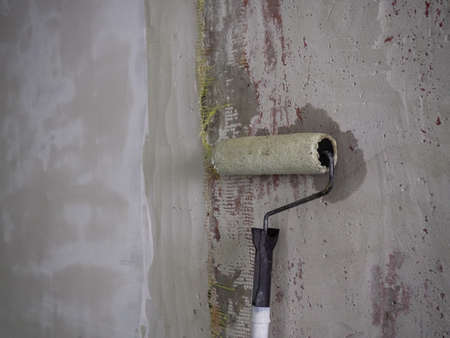 roller for repair on the background of a concrete wall, repair and design. Wall before repair.の写真素材