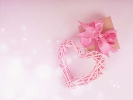 braided pink heart on a pink background, next to a gift box with a ribbon. concept of love, Valentine's day, wedding, place for text.の写真素材