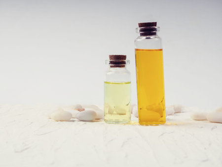 two bottles of cosmetic oil on a white background next to pebbles. the concept of health, Spa....