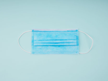 Medical mask, Medical protective mask on blue background. Disposable surgical face mask cover the mouth and nose. Healthcare and medical concept.の写真素材