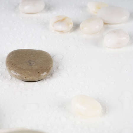 white stones and water drops on a white background as a backing.の写真素材