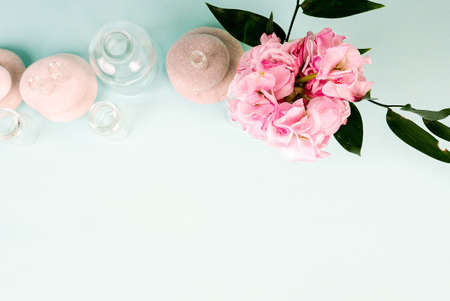 Spa stones, oil bottles and pink flower on white background.の写真素材