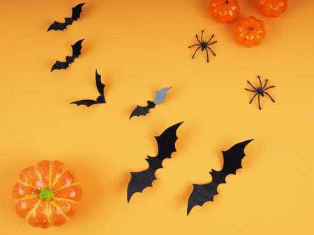 Halloween pumpkins and bats with orange background- Halloween flat lay composition.の写真素材