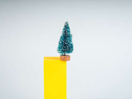 minimalism Christmas, one Christmas tree on a colored background with multi-colored abstract figures, the concept of Christmas and new year.の写真素材