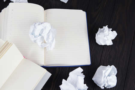 Writing concept - crumpled up paper wads with a sheet of white paper.の写真素材