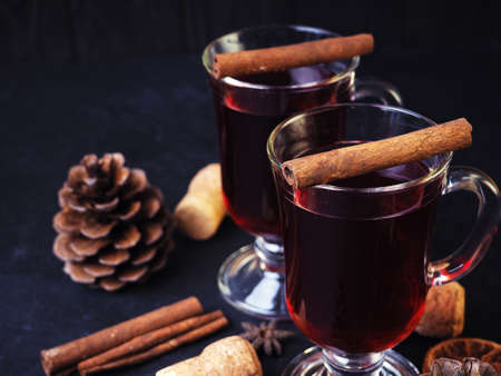 Mulled wine with spices, orange and lemon on a black table. Christmas conceptの写真素材