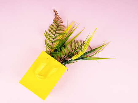 yellow flowers as a gift in a gift bag, top view.の写真素材
