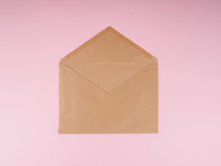Brown craft envelope on a pink background.の写真素材