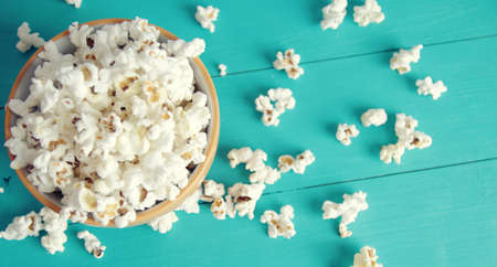 banner for web plate of popcorn on a blue wooden background, top view.の写真素材